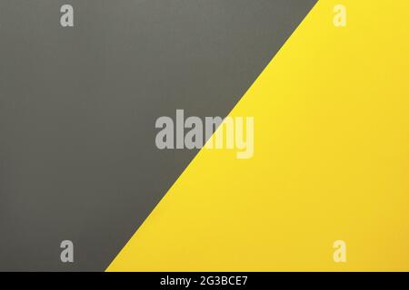 Sfondo di due colori. Fogli di carta di colore giallo e grigio divisi diagonalmente. Disposizione piatta, vista dall'alto. Foto Stock