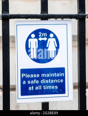 Primo piano di un cartello di allontanamento sociale nel centro di Londra, che ricorda al pubblico di mantenere una distanza di sicurezza dagli altri durante la pandemia di COVID-19 in t Foto Stock