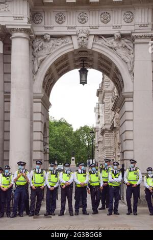 Londra, Regno Unito. 14 giugno 2021. La polizia indossa maschere facciali di protezione formano un cordone a Whitehall. I manifestanti anti anti anti anti-lockdown, anti-vaccino e anti-maschera si sono riuniti fuori dal Parlamento e da Downing Street mentre il governo ha annunciato che l'abolizione di ulteriori restrizioni COVID-19 sarà ritardata fino al 19 luglio. Foto Stock