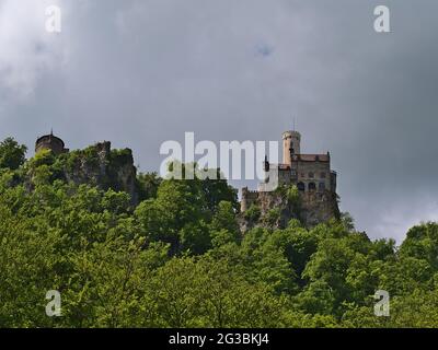 Bella vista ad angolo basso del famoso castello di Lichtenstein situato su una roccia in Alb Svevo, Germania circondato da una foresta verde nella stagione primaverile. Foto Stock