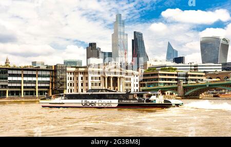 LONDRA INGHILTERRA UBER BOAT BY THAMES CLIPPERS GIRARE VELOCEMENTE SUL TAMIGI VICINO A SOUTHWARK BRIDGE GRATTACIELI IN LONTANANZA Foto Stock