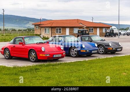 Tre Porsche Carreras (rosso, blu e nero) parcheggiate l'una accanto all'altra Foto Stock