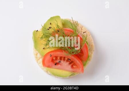 Pane di riso croccante, avocado, pomodori e aneto fresco Foto Stock