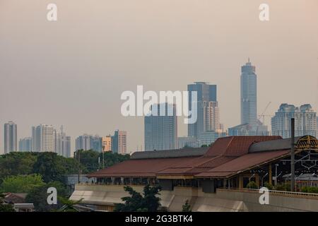 Giacarta, Indonesia - 19 ottobre 2019: La stazione ferroviaria di Gondangdia e il paesaggio urbano dei grattacieli di Giacarta sullo sfondo al tramonto Foto Stock