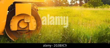 Banner costruzione area sito concetto di sviluppo, campo verde con macchinari pesanti, sviluppo terreno, spazio di copia Foto Stock
