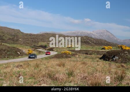 Caratteristiche colline, brughiere e laghi nelle Highlands scozzesi lungo la panoramica rotta della costa settentrionale 500 che inizia e si snoda a Inverness Foto Stock