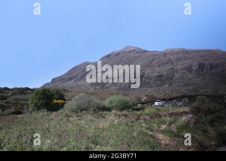 Caratteristiche colline, brughiere e laghi nelle Highlands scozzesi lungo la panoramica rotta della costa settentrionale 500 che inizia e si snoda a Inverness Foto Stock