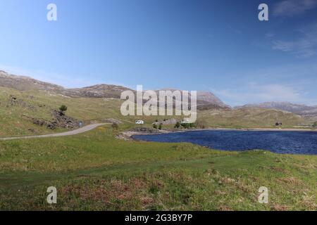 Caratteristiche colline, brughiere e laghi nelle Highlands scozzesi lungo la panoramica rotta della costa settentrionale 500 che inizia e si snoda a Inverness Foto Stock