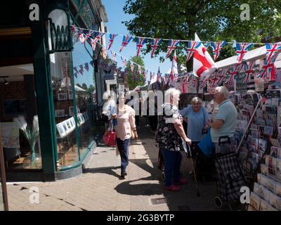 Persone che fanno acquisti presso Epping Market, Epping, Essex, Inghilterra, Regno Unito, con le bandiere Union Jack e Saint George’s Cross. Tradizionale atmosfera da mercato britannico. Foto Stock