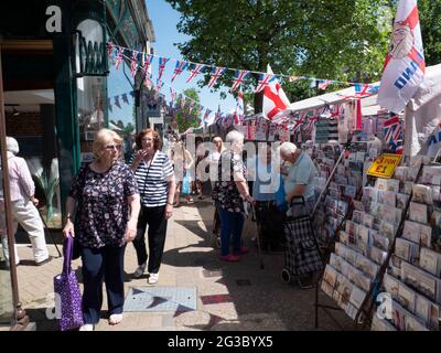 Persone che fanno acquisti presso Epping Market, Epping, Essex, Inghilterra, Regno Unito, con le bandiere Union Jack e Saint George’s Cross. Tradizionale atmosfera da mercato britannico. Foto Stock