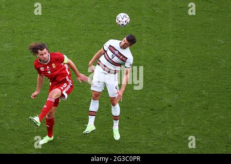 BUDAPEST, UNGHERIA - GIUGNO 15: Ádám Szalai (C) (9) dall'Ungheria salta per una testata con il portoghese Rúben Dias (4) durante la partita al Campionato UEFA Euro 2020 Gruppo F tra Ungheria e Portogallo il 15 giugno 2021 a Budapest, Ungheria. (Foto di MB Media) Foto Stock