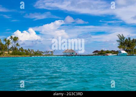 I bungallows sull'acqua all'Atollo Sud di Male, le Maldive dell'isola di Olhuveli all'Oceano Indiano, l'isola con le spiagge fiancheggiate da palme e un resort all-inclusive Foto Stock