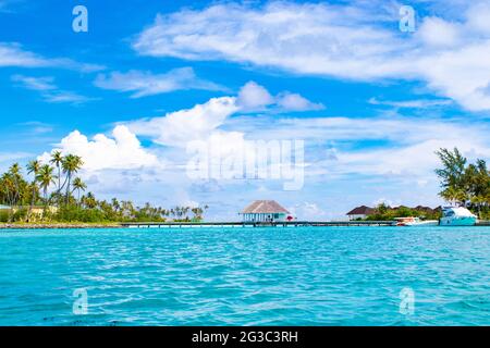 I bungallows sull'acqua all'Atollo Sud di Male, le Maldive dell'isola di Olhuveli all'Oceano Indiano, l'isola con le spiagge fiancheggiate da palme e un resort all-inclusive Foto Stock