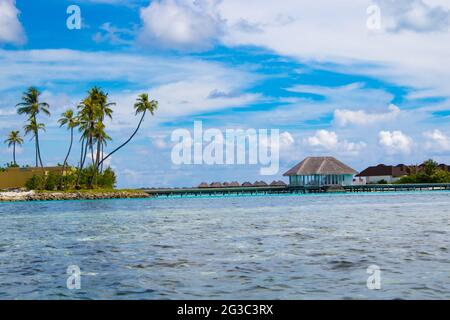 I bungallows sull'acqua all'Atollo Sud di Male, le Maldive dell'isola di Olhuveli all'Oceano Indiano, l'isola con le spiagge fiancheggiate da palme e un resort all-inclusive Foto Stock