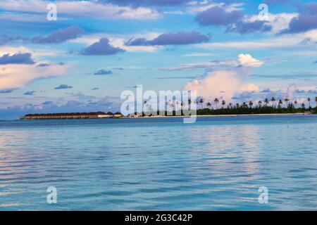 I bungallows sull'acqua all'Atollo Sud di Male, le Maldive dell'isola di Olhuveli all'Oceano Indiano, l'isola con le spiagge fiancheggiate da palme e un resort all-inclusive Foto Stock