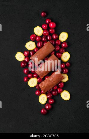 Composizione superiore con frittelle di cioccolato sottili farcite di cagliata, ciliegia e banana Foto Stock