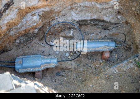 cantiere, foro nel terreno con un connettore per cavo interrato Foto Stock