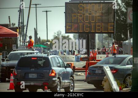 Gli automobilisti passano un cartello illuminato che li dirige verso un sito di vaccinazione del coronavirus ad Anaheim, California. Foto Stock