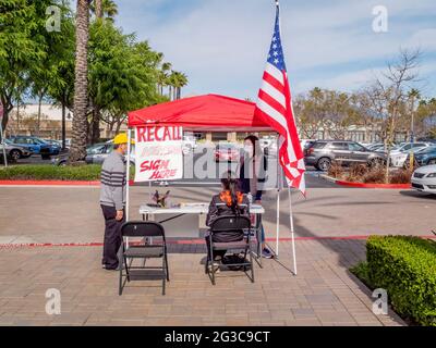 Le donne volontarie su un Aliso Viejo, CA, shopping plaza Sidewalk raccogliere le firme di petizione per il richiamo del governatore della California Newsom Foto Stock