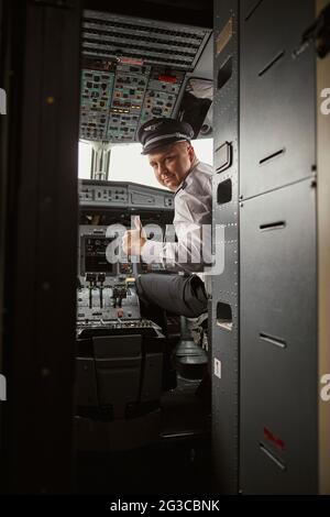 Il pilota mostra il gesto del pollice verso l'alto nella cabina di pilotaggio dell'aeroplano Foto Stock