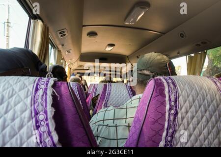 Passeggeri seduti in minibus, vista dal sedile dietro Foto Stock