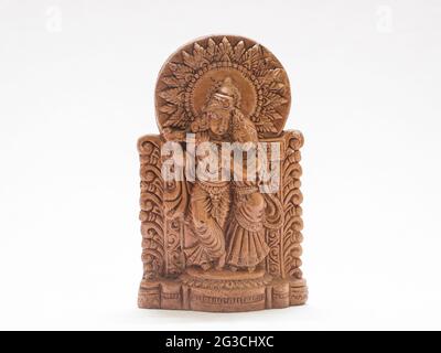 Primo piano di una piccola statua del signore Krishna e Radha isolata su uno sfondo bianco Foto Stock