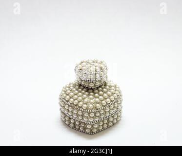 Closeup di due scatole di gioielli a forma di cuore con perle isolate su uno sfondo bianco Foto Stock