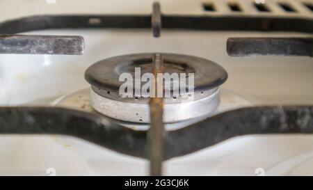 Stufa a gas sporca in cucina per cucinare con macchie di olio vegetale e detriti di cibo bruciato sulla superficie, primo piano. Messa a fuoco selettiva. G ricoperti di grasso Foto Stock