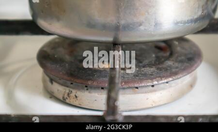 Stufa a gas sporca in cucina per cucinare con macchie di olio vegetale e detriti di cibo bruciato sulla superficie, primo piano. Messa a fuoco selettiva. G ricoperti di grasso Foto Stock