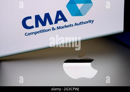 Logo Apple sulla superficie del macbook e logo del concorso CMA britannico e della Markets Authority sfocati visualizzati sullo schermo dello smartphone. Concetto. Stafford, Re Unito Foto Stock