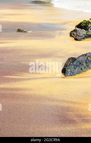 Sabbia colorata sulla spiaggia di Mirissa con onde oceaniche Foto Stock