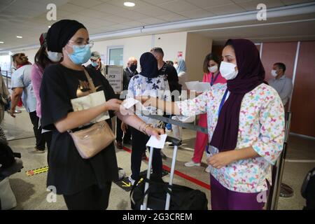 (210615) -- CASABLANCA (MAROCCO), 15 giugno 2021 (Xinhua) -- un membro dello staff aeroportuale (R, Front) controlla il risultato del test PCR COVID-19 di un viaggiatore all'aeroporto internazionale Mohammed V di Casablanca, Marocco, il 15 giugno 2021. Il Marocco ha allentato le restrizioni di frontiera e ha permesso ai passeggeri internazionali di entrare nel paese a partire da martedì prima della stagione turistica. (Ningbo) Foto Stock