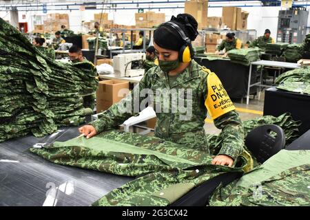 CITTÀ DEL MESSICO, MESSICO - GIUGNO 15: Un militare produce uniformi per i membri dell'esercito messicano presso la fabbrica di abbigliamento e attrezzature militari fondata a 1951. I lavoratori militari producono più di 3,000 uniformi al giorno, fabbricate con tessuto da loro fatto per uso esclusivo per l'esercito messicano. Il 15 giugno 2021 a Città del Messico, Messico. Foto Stock
