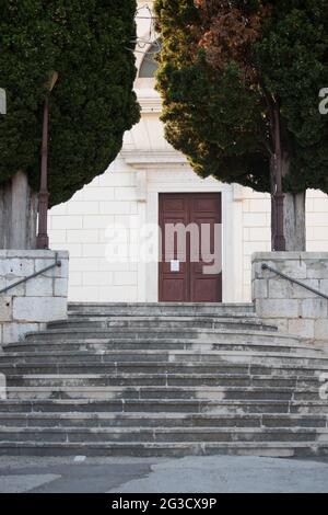Immagine verticale di un'ampia scalinata ad un edificio in pietra bianca con porta d'ingresso al centro Foto Stock