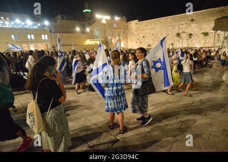 Gerusalemme, Israele. 15 Giu 2021 . Marcia ultranazionalista israeliana delle bandiere. Madre e figlia ondeggiano bandiere nella Western Wall Plaza nella città vecchia di Gerusalemme, celebrando l'anniversario dell'occupazione israeliana del settore orientale nel 1967. Foto Stock