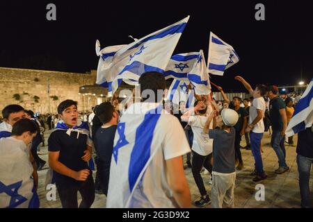 Gerusalemme, Israele. 15 Giu 2021 . Marcia ultranazionalista israeliana delle bandiere. I giovani indossano e ondeggiano bandiere nella Western Wall Plaza nella città vecchia di Gerusalemme, celebrando l'anniversario dell'occupazione israeliana del settore orientale di Gerusalemme nel 1967. Foto Stock