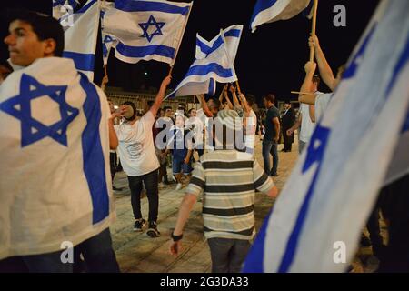 Gerusalemme, Israele. 15 Giu 2021 . Marcia ultranazionalista israeliana delle bandiere. I giovani indossano e ondeggiano bandiere nella Western Wall Plaza nella città vecchia di Gerusalemme, celebrando l'anniversario dell'occupazione israeliana del settore orientale di Gerusalemme nel 1967. Foto Stock