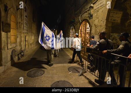 Gerusalemme, Israele. 15 Giu 2021 . Marcia ultranazionalista israeliana delle bandiere. Il poliziotto apre un passaggio ai giovani sventolando una bandiera nella città vecchia di Gerusalemme, celebrando l'anniversario dell'occupazione israeliana del settore orientale di Gerusalemme nel 1967. Foto Stock