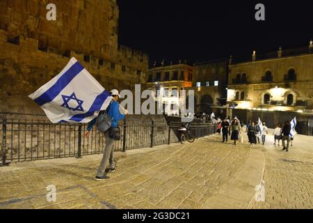 Gerusalemme, Israele. 15 Giu 2021 . Marcia ultranazionalista israeliana delle bandiere. Un uomo svonda una bandiera nella città vecchia di Gerusalemme, celebrando l'anniversario dell'occupazione israeliana nel 1967 del settore orientale di Gerusalemme. Foto Stock