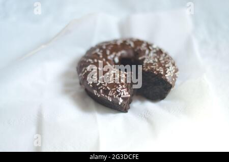Primo piano di una deliziosa ciambella di cioccolato amaro su un tovagliolo Foto Stock