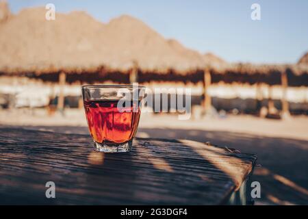 Tè nero orientale in vetro su un tappeto orientale. Concetto di tè orientale. Tazza tradizionale Armudu. Messa a fuoco selettiva Foto Stock
