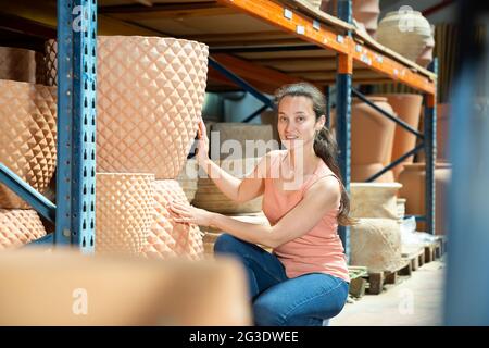 Giovane cliente donna che tiene grande creta decorativa pentola per giardino Foto Stock