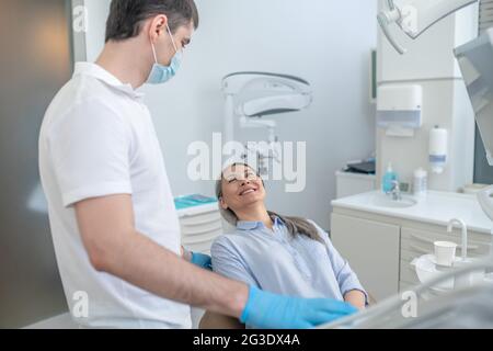 Paziente e dentista in ufficio dentistico pronto per l'intervento chirurgico Foto Stock