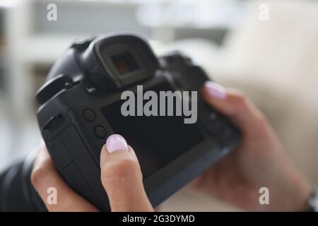 Il fotografo tiene la macchina fotografica nel suo closeup delle mani Foto Stock