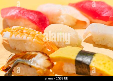 Primo piano su pezzi di sushi o di riso nigirizushi pressati a mano con vari frutti di mare, tra cui congridae di anago giapponese, uova alla griglia di tamagoyaki o gamberi Foto Stock
