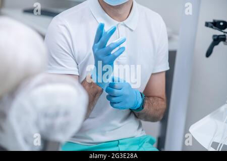 Primo piano immagine di un medico che indossa guanti sterili Foto Stock