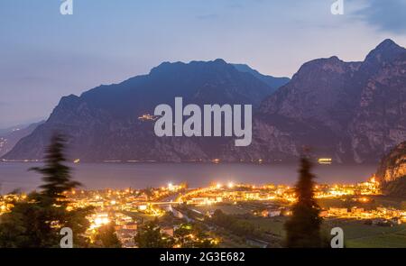 Nago Torbole, Italia. 14 Giugno 2021. Le luci del villaggio brillano nel crepuscolo. Nago-Torbole è la città più settentrionale del Lago di Garda. Credit: Daniel Reinhardt/dpa/Alamy Live News Foto Stock