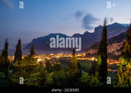 Nago Torbole, Italia. 14 Giugno 2021. Le luci del villaggio brillano nel crepuscolo. Nago-Torbole è la città più settentrionale del Lago di Garda. Credit: Daniel Reinhardt/dpa/Alamy Live News Foto Stock