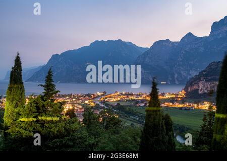 Nago Torbole, Italia. 14 Giugno 2021. Le luci del villaggio brillano nel crepuscolo. Nago-Torbole è la città più settentrionale del Lago di Garda. Credit: Daniel Reinhardt/dpa/Alamy Live News Foto Stock