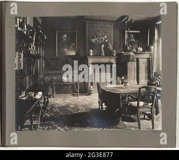 Sala da pranzo della villa al piano terra intorno al 1920 .. Sala da pranzo vista a nord con in mezzo alla stanza, un tavolo con sedie. A sinistra al muro si trovano i tavoli e le pareti sono tappezzate con dipinti. Le pareti sono realizzate con pannelli e carta da parati colorata. L'iscrizione è sul camino in arenaria: 'East West casa migliore'. Sopra il camino uno stemma. Il soffitto sembra rifinito con una pianta a doghe. Questa sala è attualmente divisa in due uffici. Foto Stock